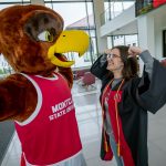 Rocky and a graduate flex their muscles.