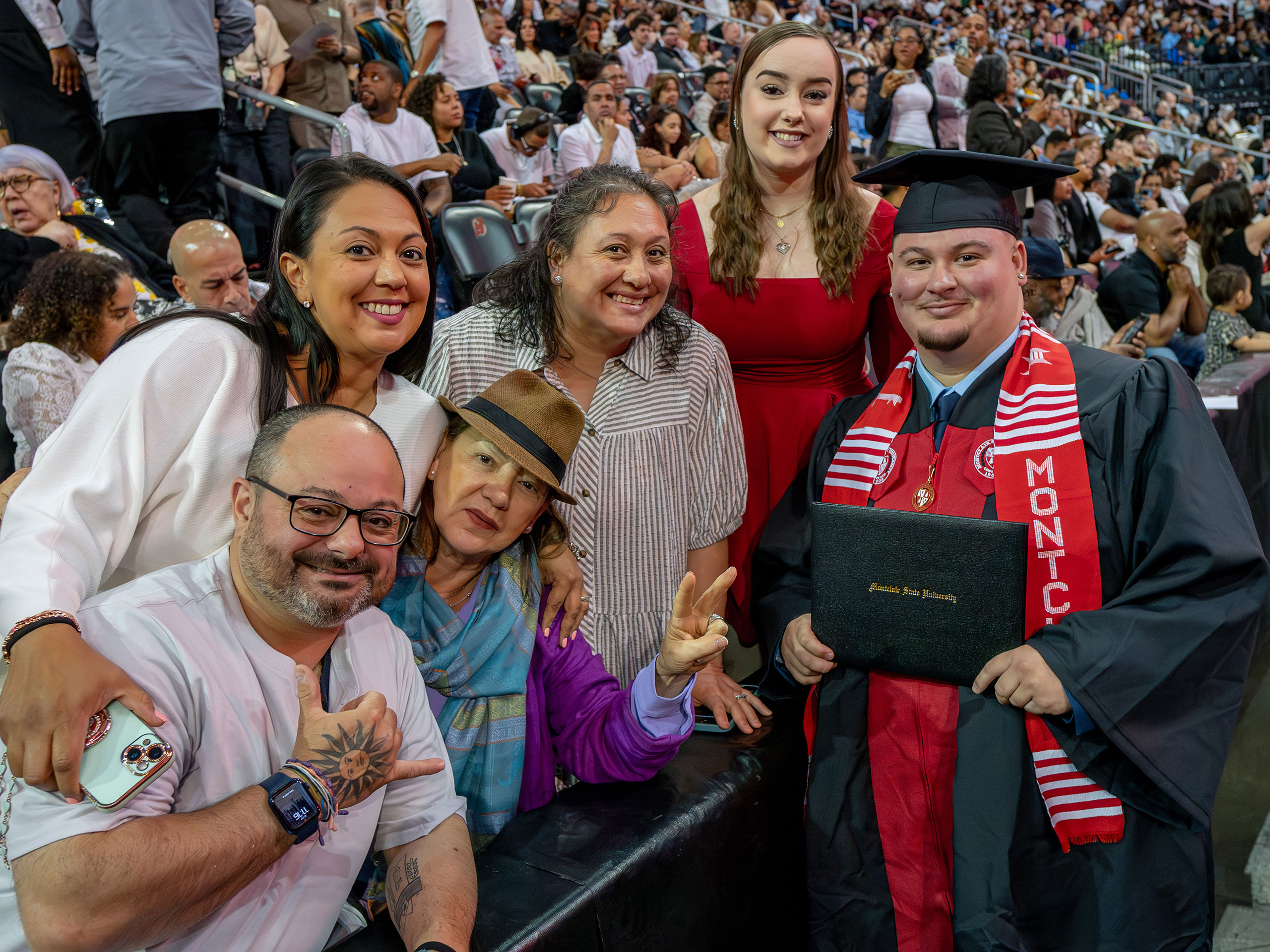 A family of five poses with their graduate inside Prudential Center