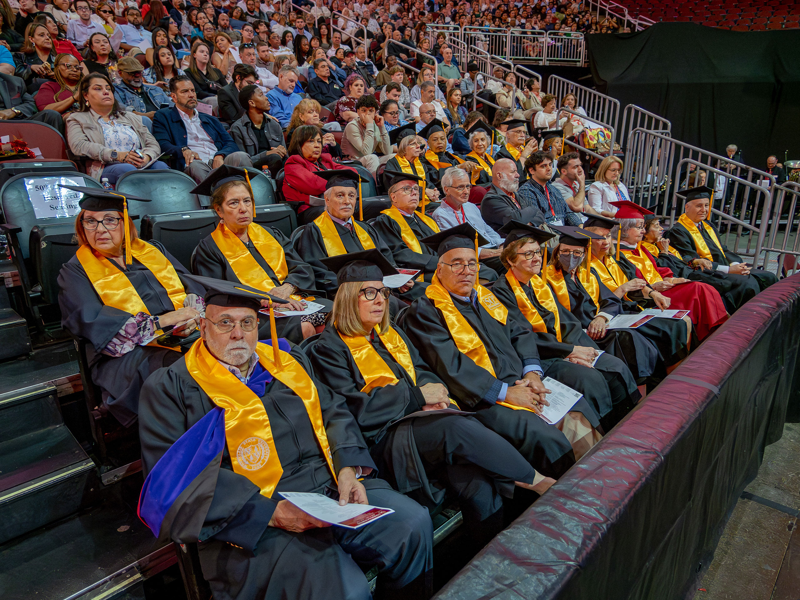 a group of alumni seated in caps and robes for the 50th anniversary of their graduation