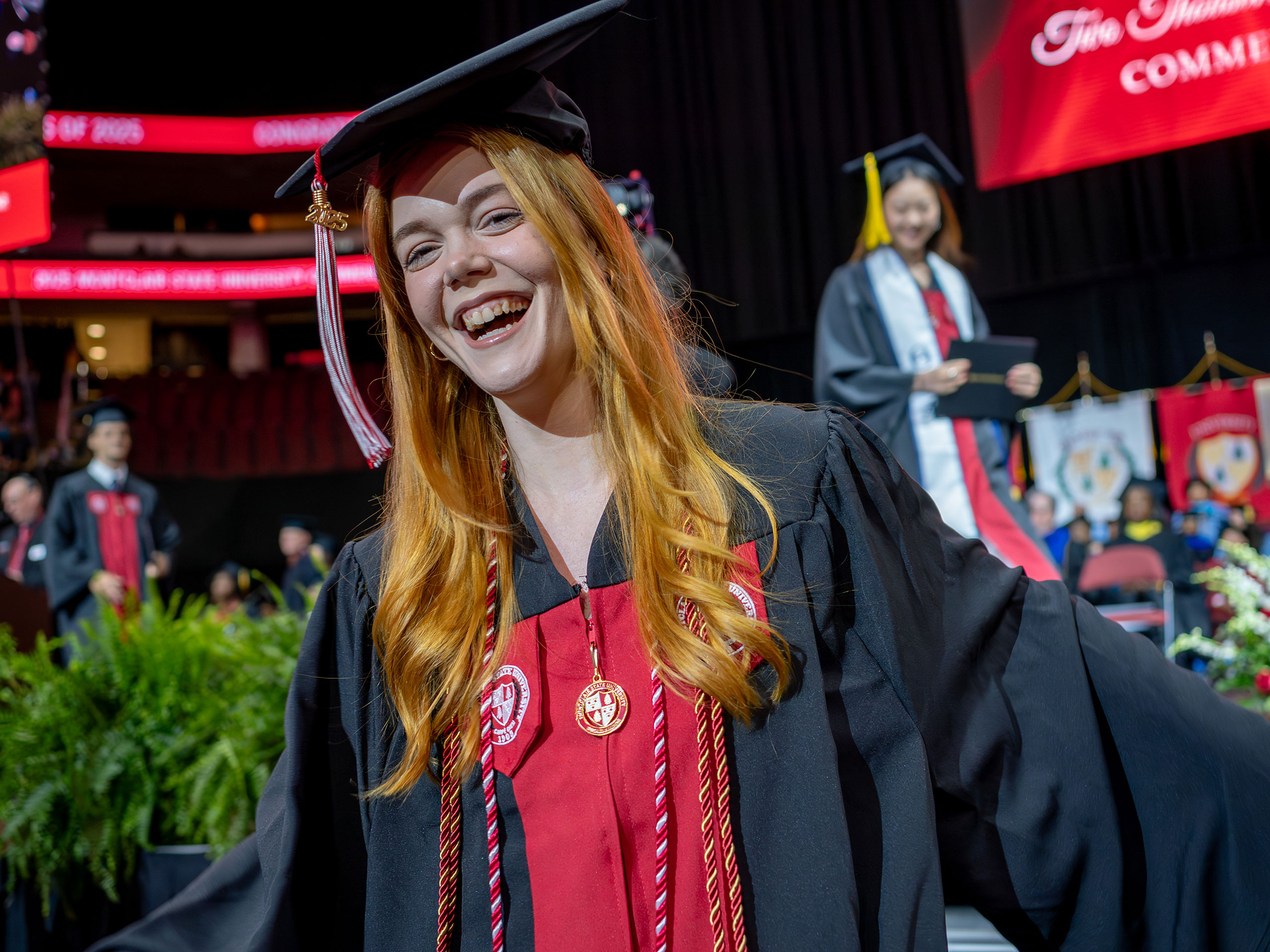 graduate in black cap and gown smiling after receiving diploma