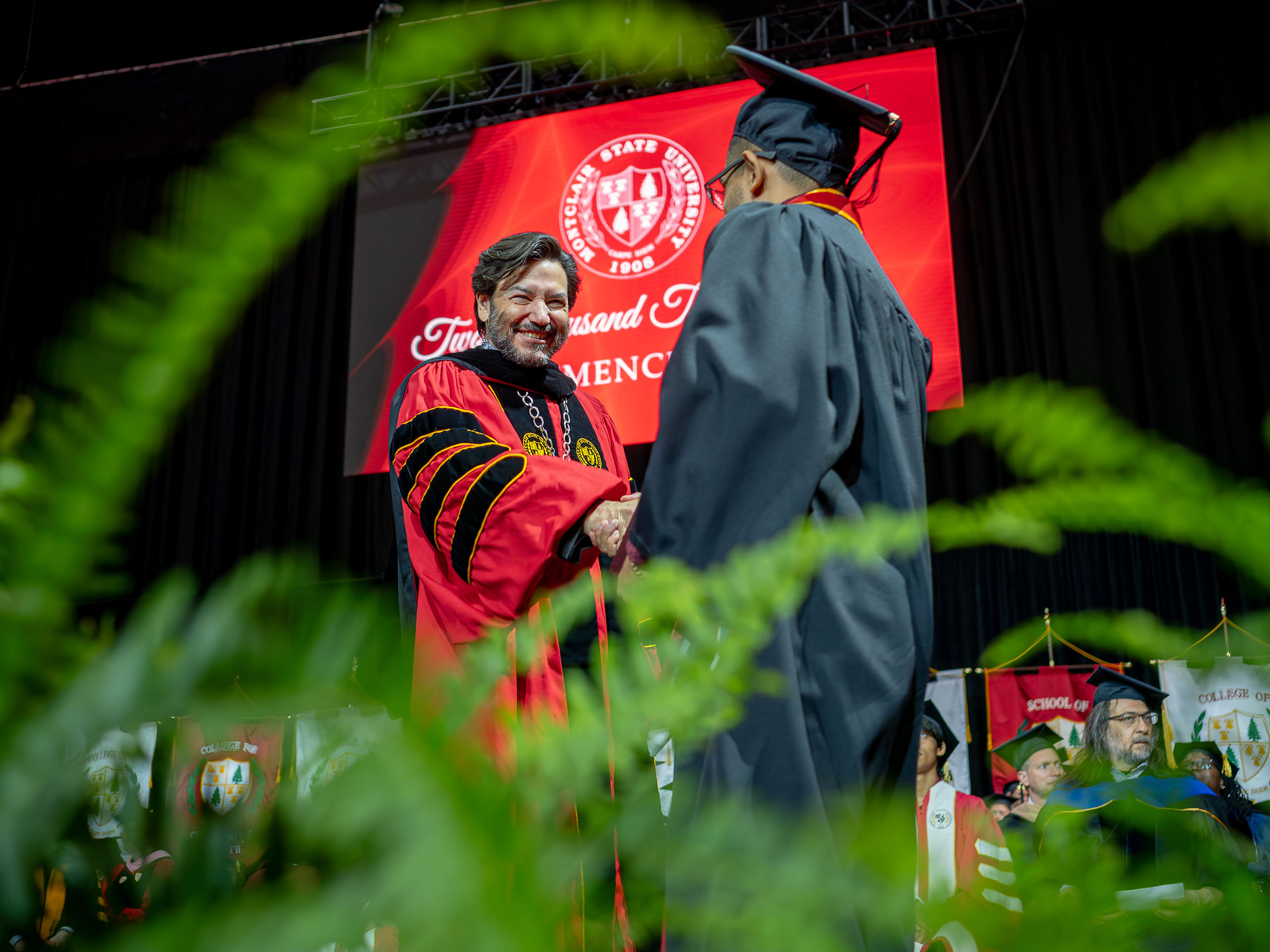 President Koppell shaking hands with a graduate on stage