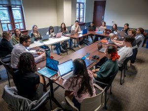 Sociology Professor Christopher Donoghue leads a group of students in an “Honors Creativity” class at Montclair, with students seated around tables working on laptops and collaborating in a bright, windowed classroom. (Photo by University Photographer Mike Peters)