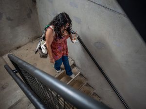 Sara Flores walks down a staircase at Dinallo Heights, a residence hall at Montclair State University.