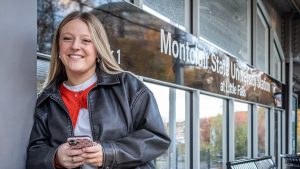 Emma Haskell stands on a train platform at the Montclair State University Station.