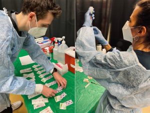 School of Nursing students in protective gear preparing to administer COVID-19 vaccinations.