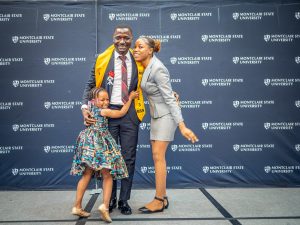 Male nursing student receives his pin from his daughter and cousin at the Pinning Ceremony.