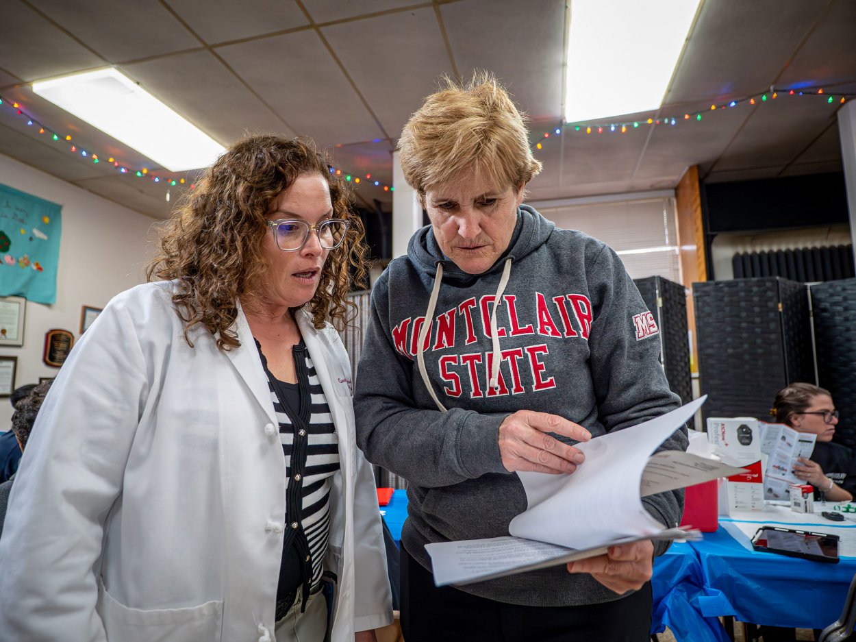 School of Nursing professors reviewing paperwork for health screening.