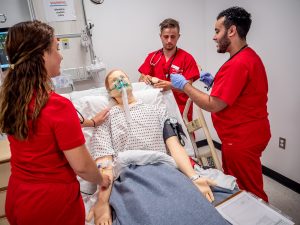 Three nursing students working with an intelligent nursing simulator.
