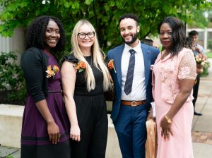 Four School of Nursing faculty members standing in front of Memorial Auditorium.