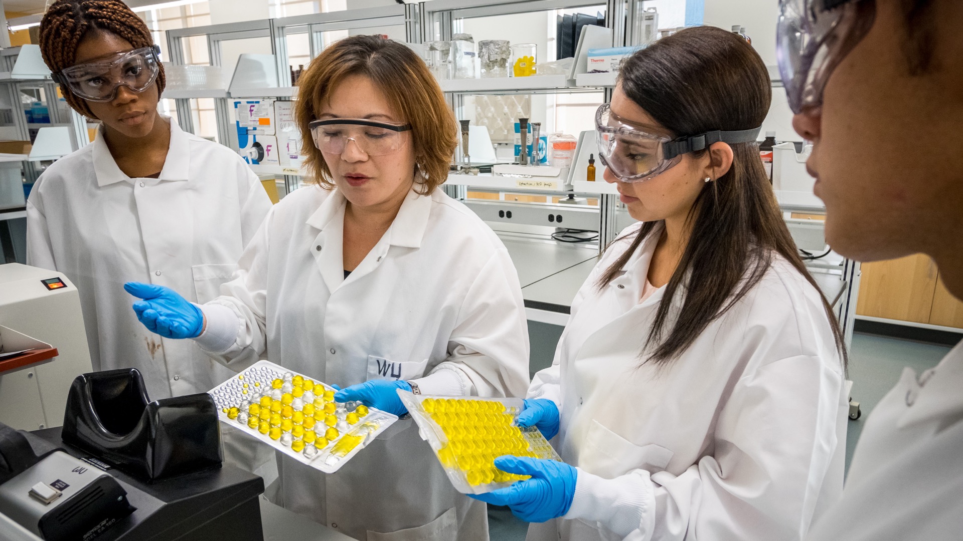 Professor and students in lab performing experiments.