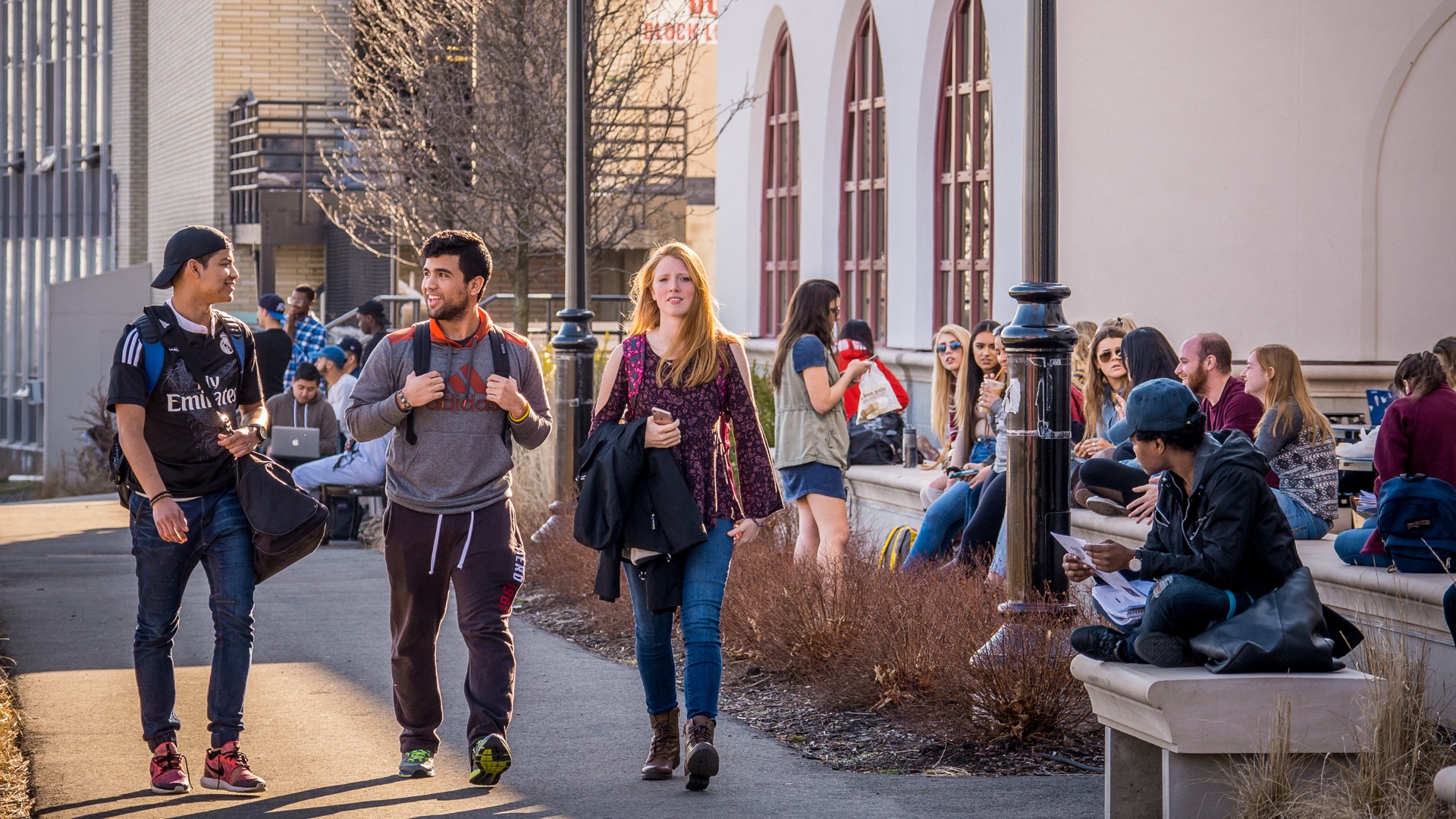Three students walking on campus.