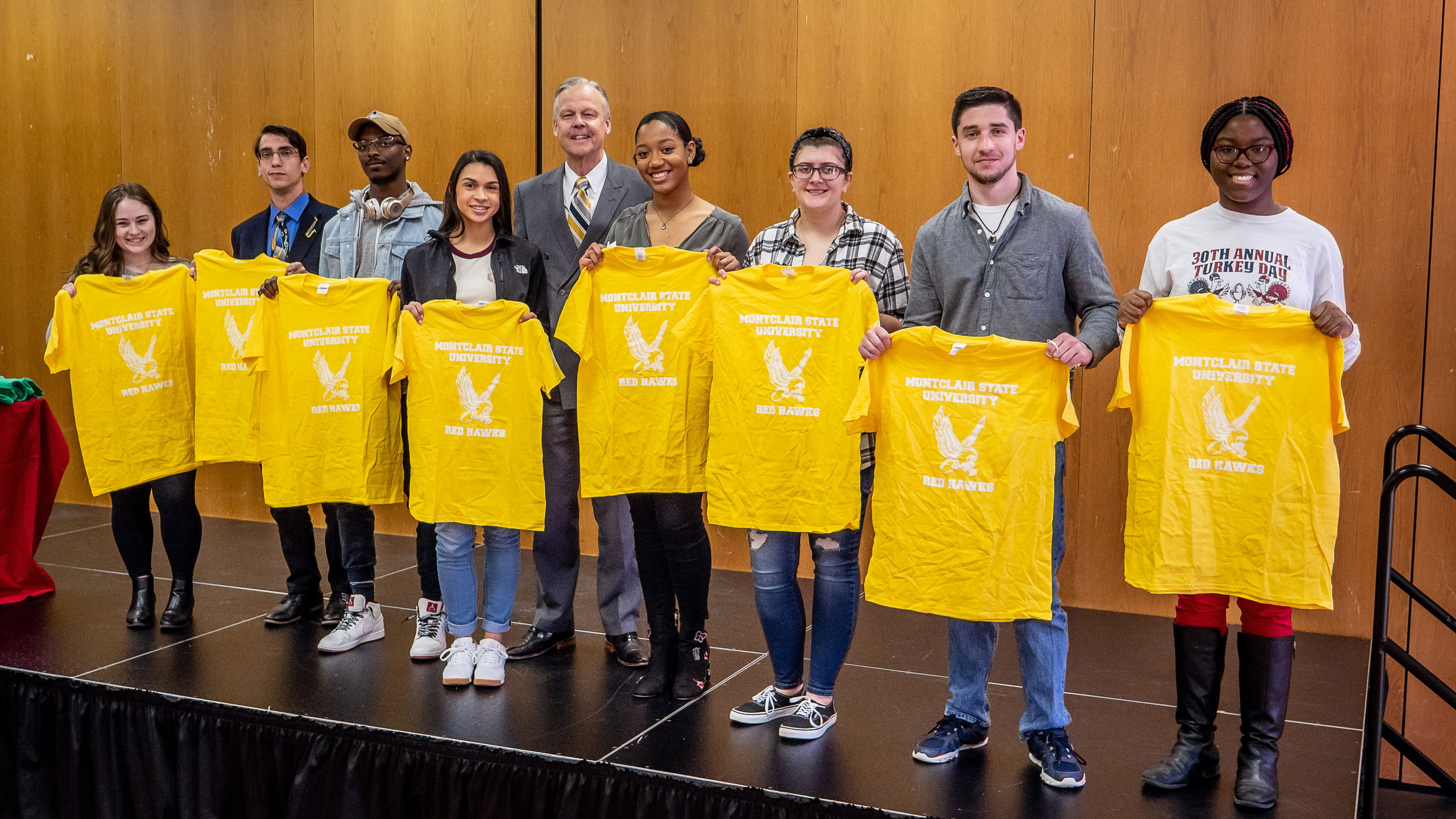 Students holding yellow shirts representing University College