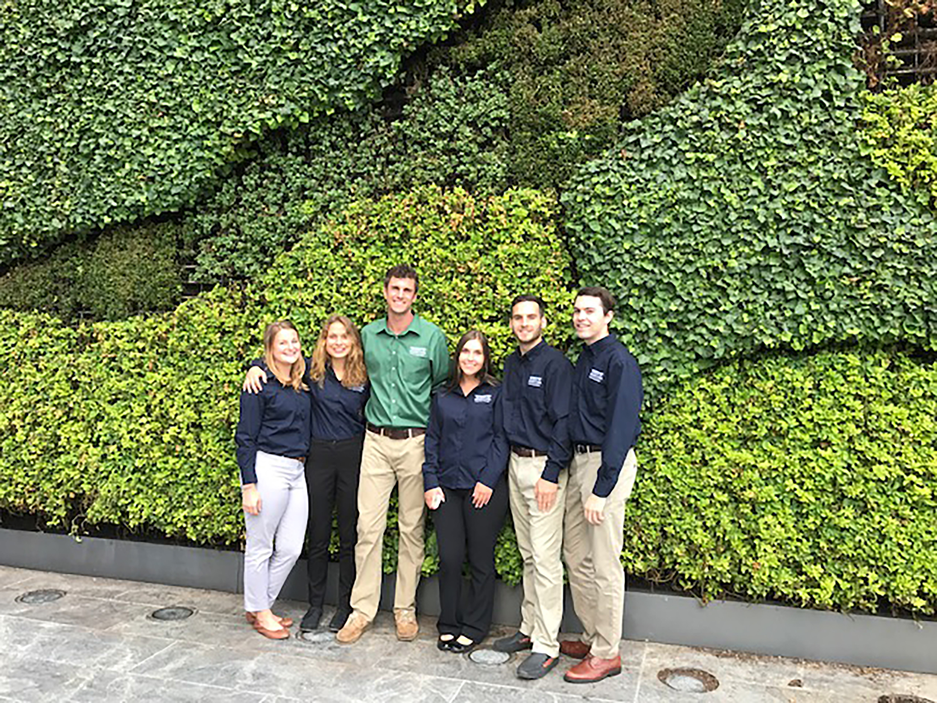 Prudential Green Team group photo in front of vine wall