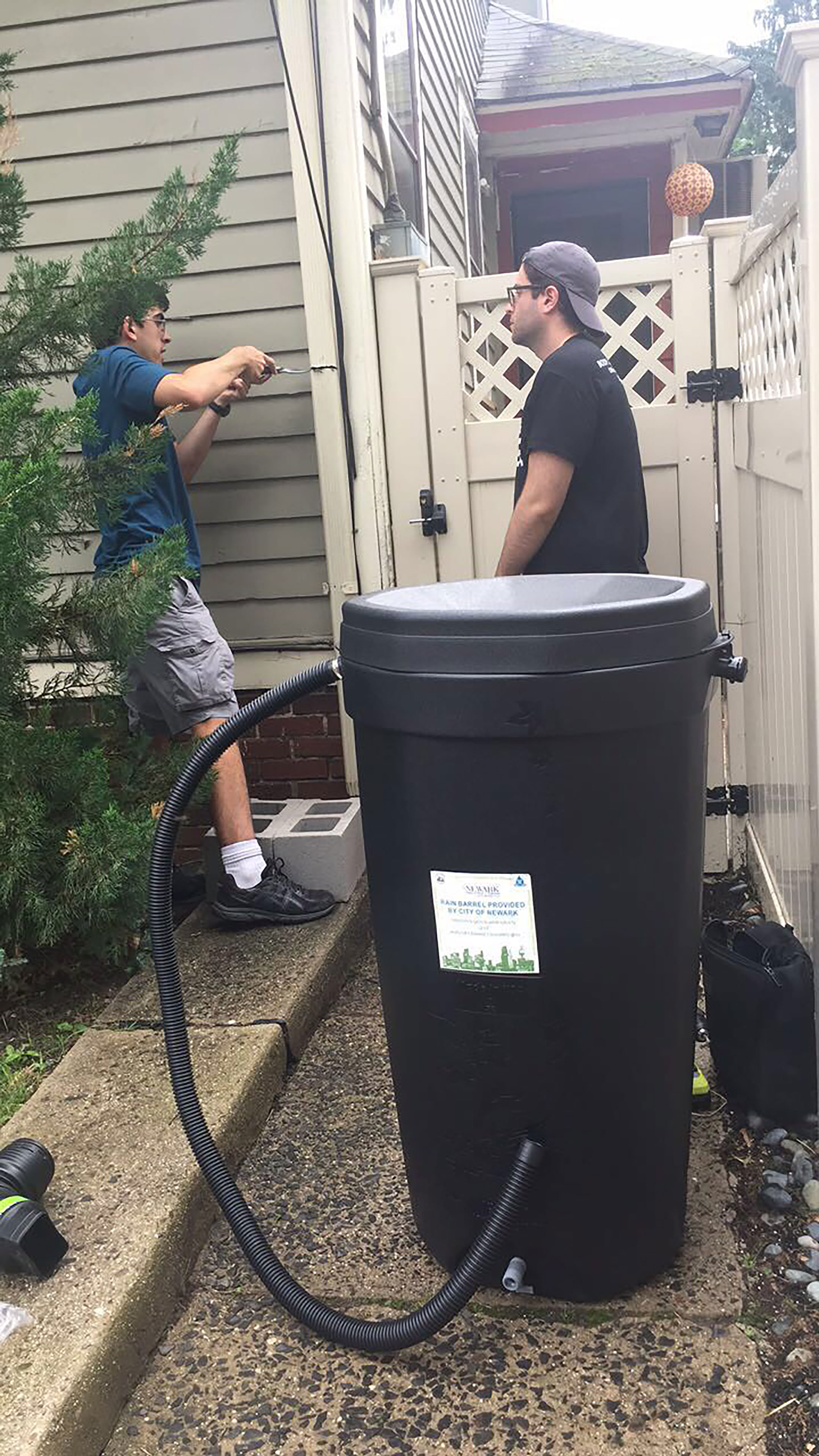team Newark installing rain barrel in home