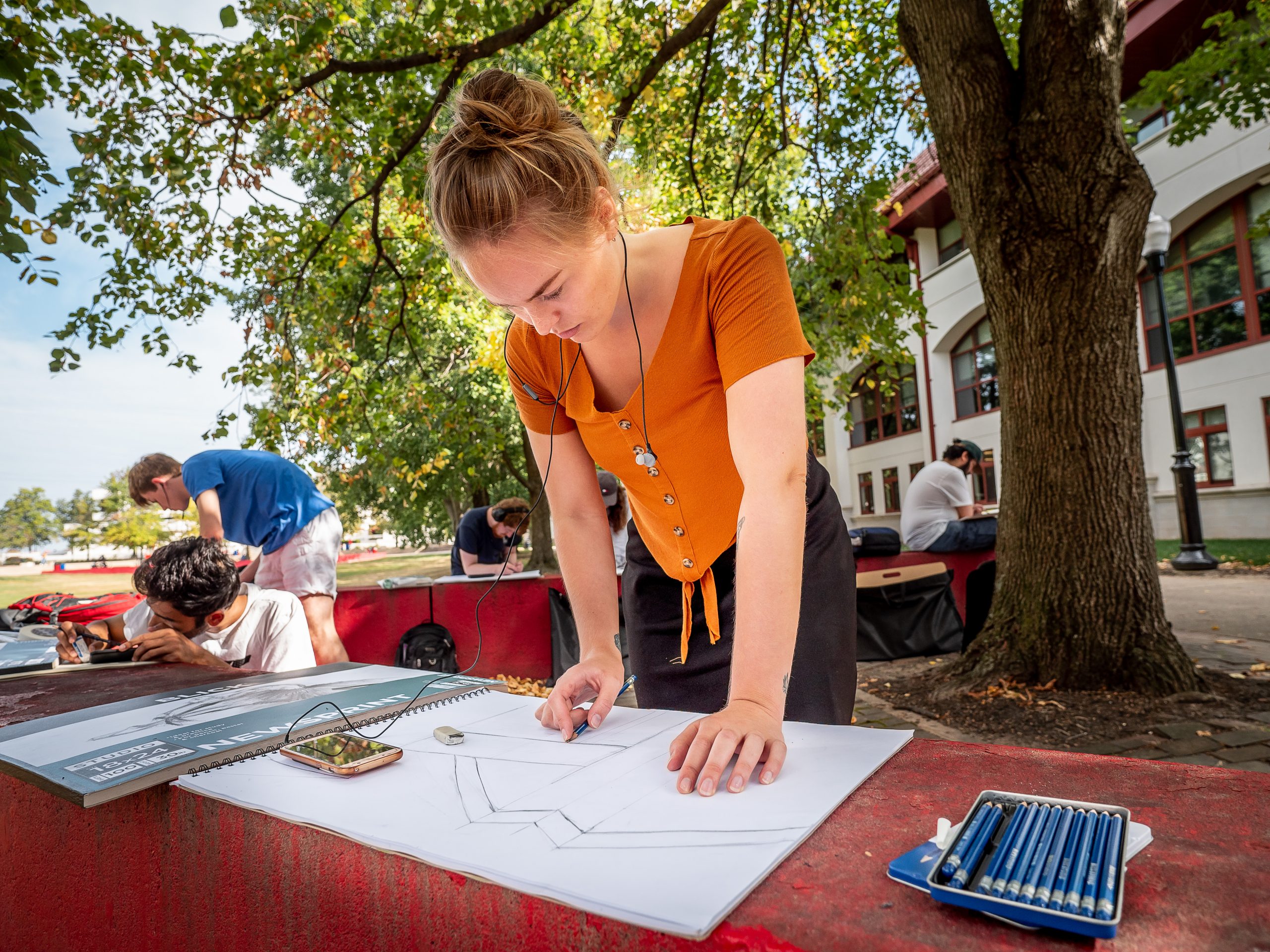 Student drawing outside.