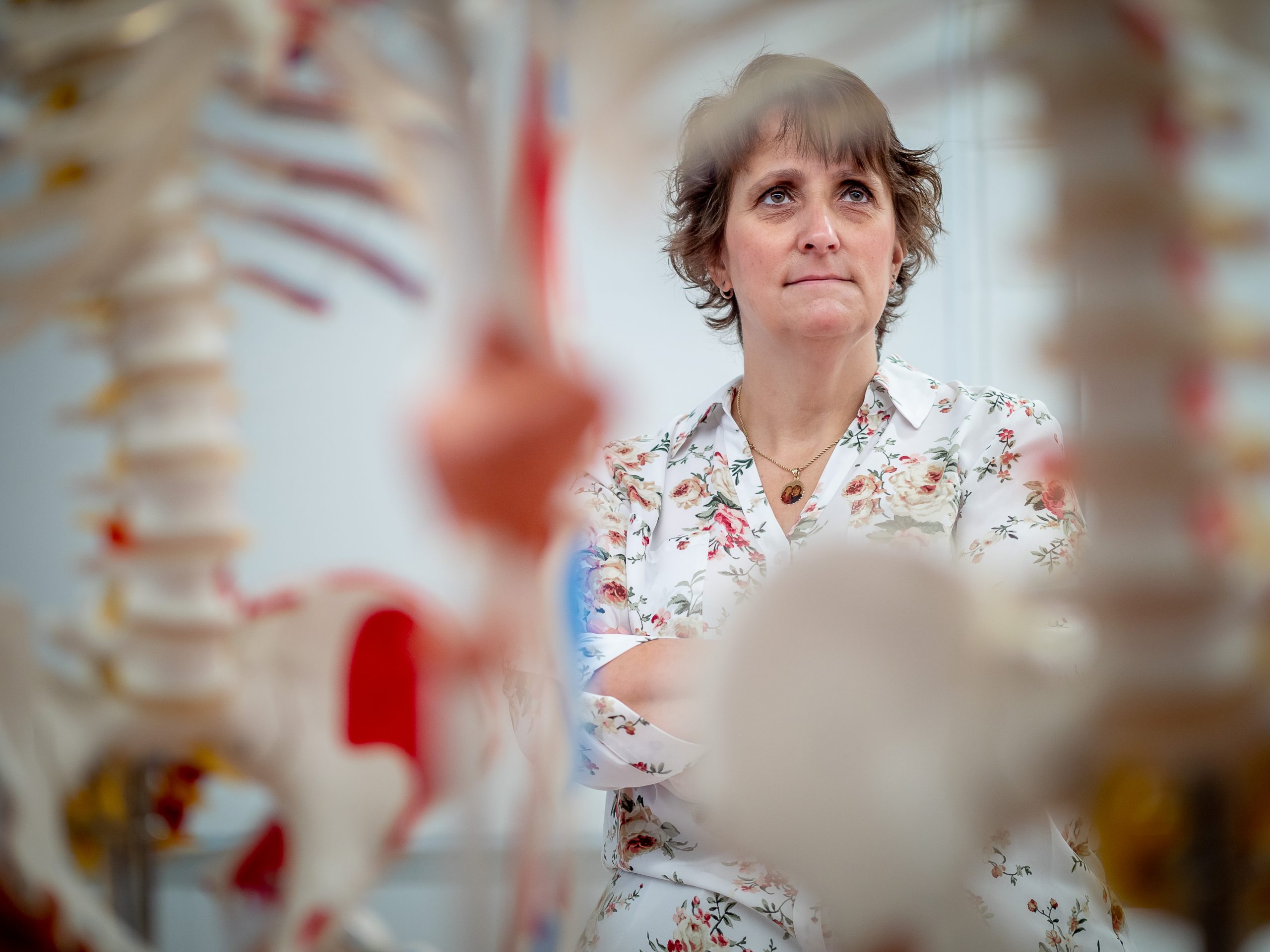 Professor looking at fake skeletons for medical studies.