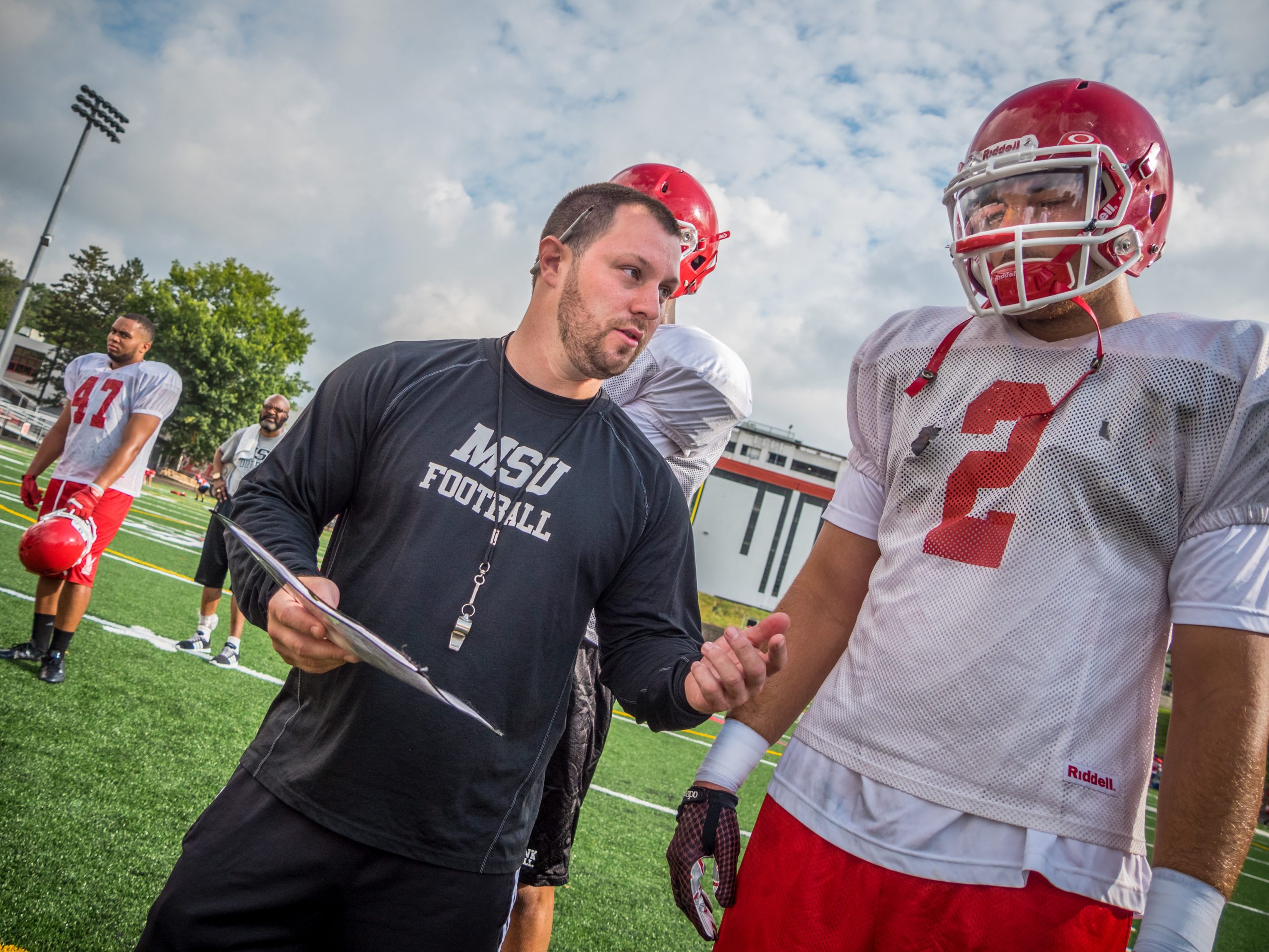Montclair State Univesrity football coach talking to a player.