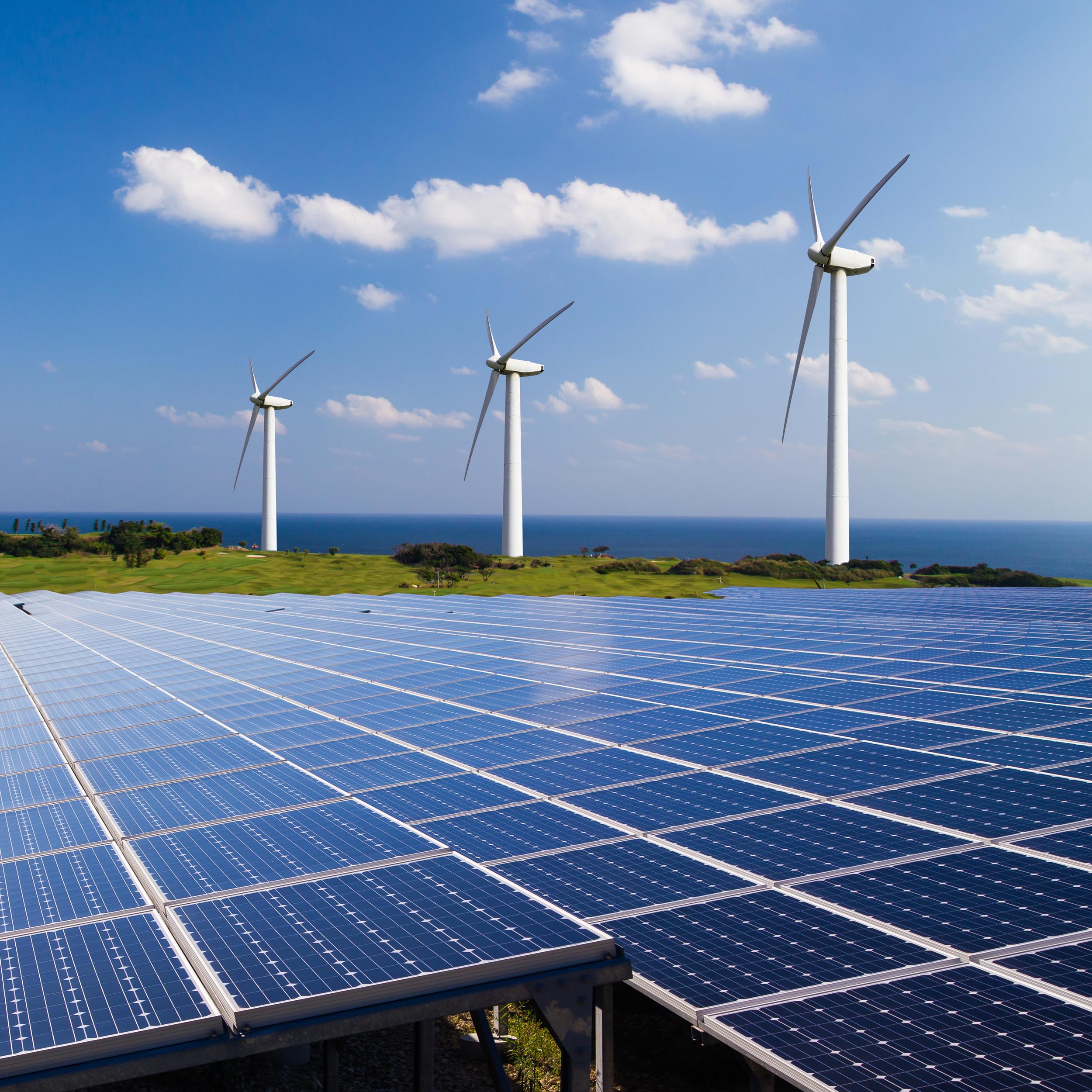 Wind turbines and solar panels under a blue sky