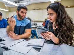 Photo of students at lab bench calculating results.