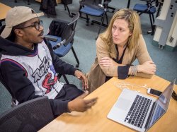 Photo of two students talking in a classroom.