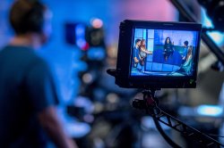 Photo of camera viewfinder showing a round table of pundit students