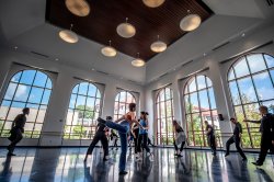 Graduate students stretch in dance class.