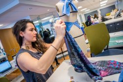 Student holds up a piece of printed fabric