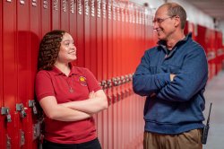 A principal talks with a teacher in a school setting.