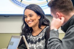 student smiling while talking to other students