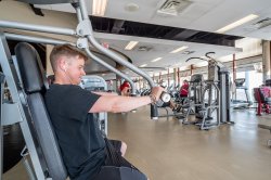 A student uses weight lifting equipment in a gym