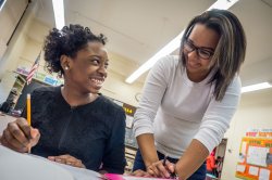 A teacher helps a student with an assignment.