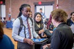 Students at job fair, speaking with a representative