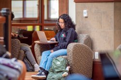 Student studying on laptop in lounge