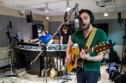 Students record a singer in the studio.