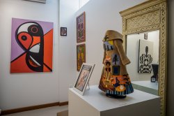 An art gallery exhibition featuring paintings and sculptures with an African influence