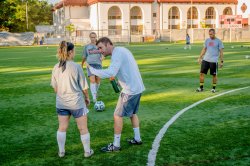 A soccer player receives coaching on the field