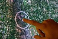 A close-up image of a finger pointing to Montclair on a map