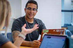Students talking with laptops in front of them