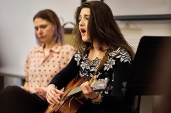 A Music Therapy student sings and plays guitar.