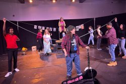 students on stage, holding string to lay out a set