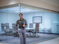 Photo of a man standing in front of a conference room.