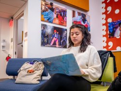 Montclair student engaged in online learning, working on a laptop in a focused, remote study environment