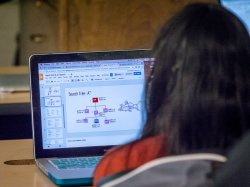 Student working on code and data analysis on a laptop.