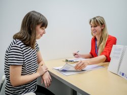 a psychologist speaking to a student as they go through papers together