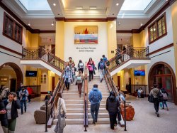 Crowd of students walking up and down the stairs of the Feliciano School of Business building.