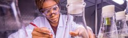 student reaching for beaker with test sample