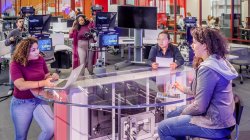 reverse view of student news production, showing producers and camera operators