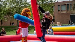 Rocky and a student jousting on inflatable trampoline