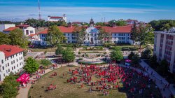 An aerial shot of campus with a crowd of students gathered in red shirts