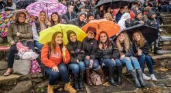 Photo of students and alumni in the rain at Homecoming 2016
